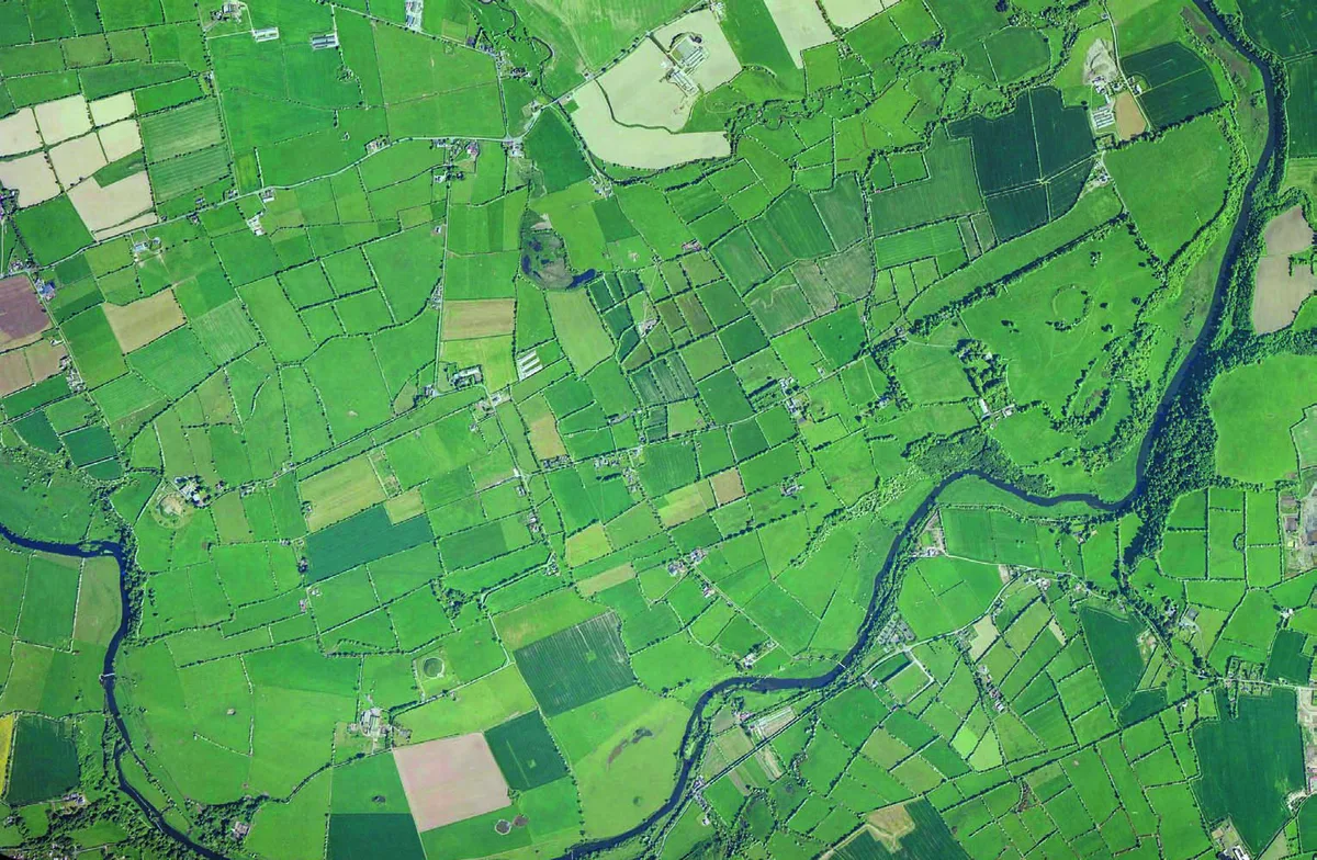 Aerial photograph of the Bend of the Boyne, green fields and farmsteads wrapped by a dark river, from the cover of the 2008 consultation draft.