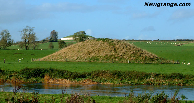 Grassy mound of Newgrange Site B beside the River Boyne, with the white quartz facade of Newgrange on the ridge behind.