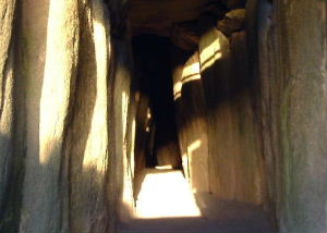 Winter solstice sunlight on the floor of the Newgrange passage between grey orthostats.