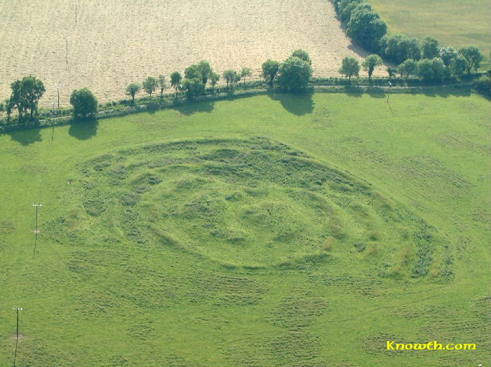 Aerial view of Tlachtga, a circular prehistoric earthwork with internal ridges in a green field.