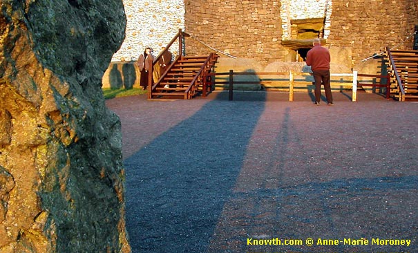 Long shadow from standing stone GC1 toward kerbstone K2 at Newgrange winter solstice sunrise.